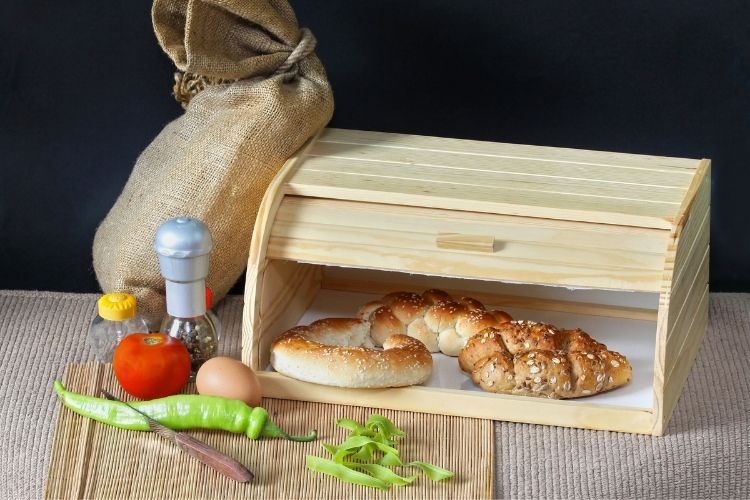 roll top Bread box styled wit loaves of bread and product