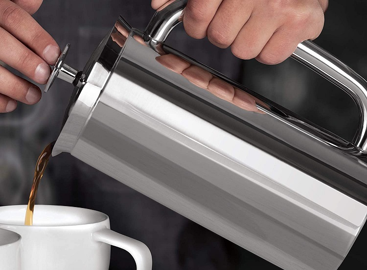 person pouring out of stainless steel french press coffee maker