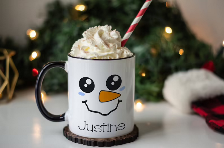 Snowman Face Mug personalized with name JUSTINE and filled with shipped cream and straw