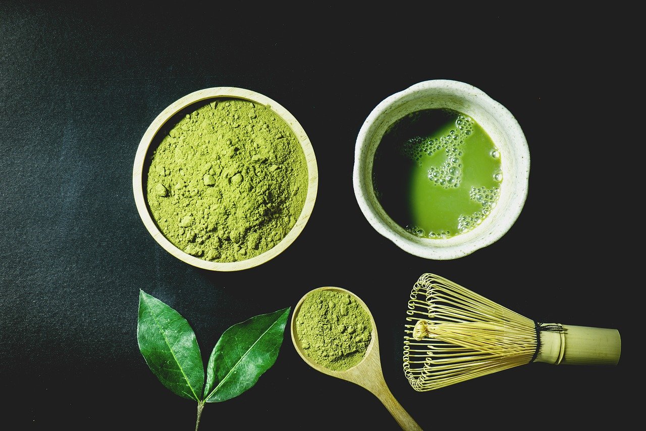 flatlay of matcha green tea powder with accessories