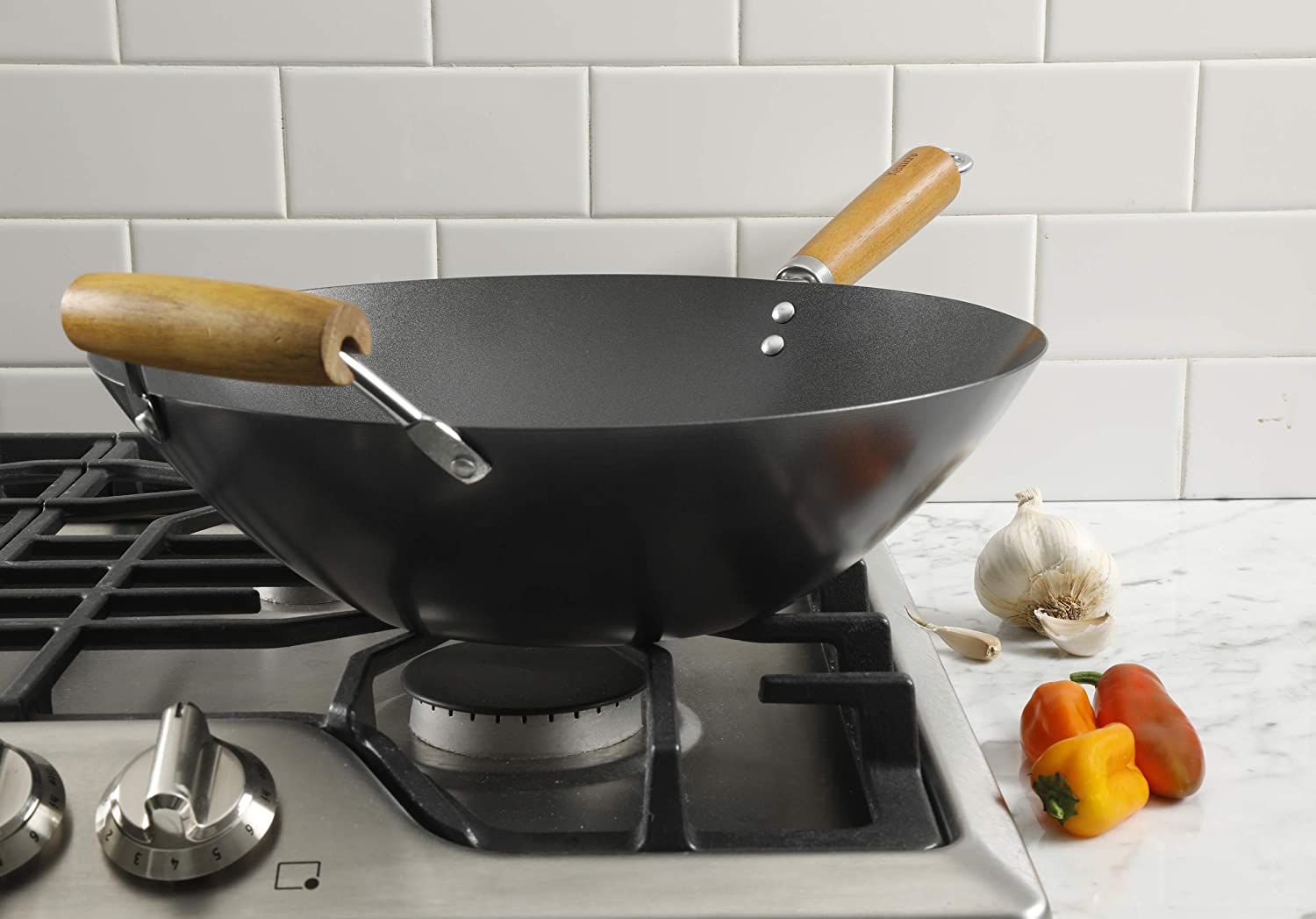 black wok on stove with wooden handles