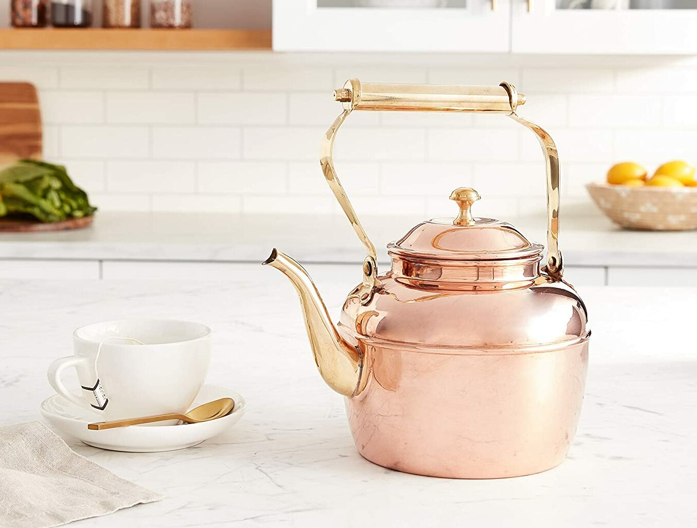 copper tea kettle on counter next to tea mug