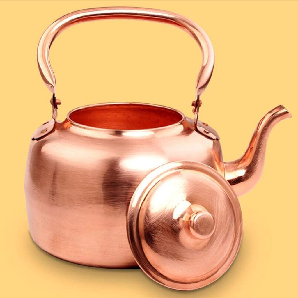 copper tea kettle on yellow background