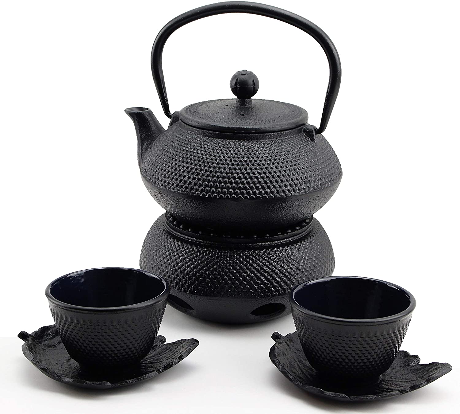 cast iron textured tea kettle with two cups and saucers