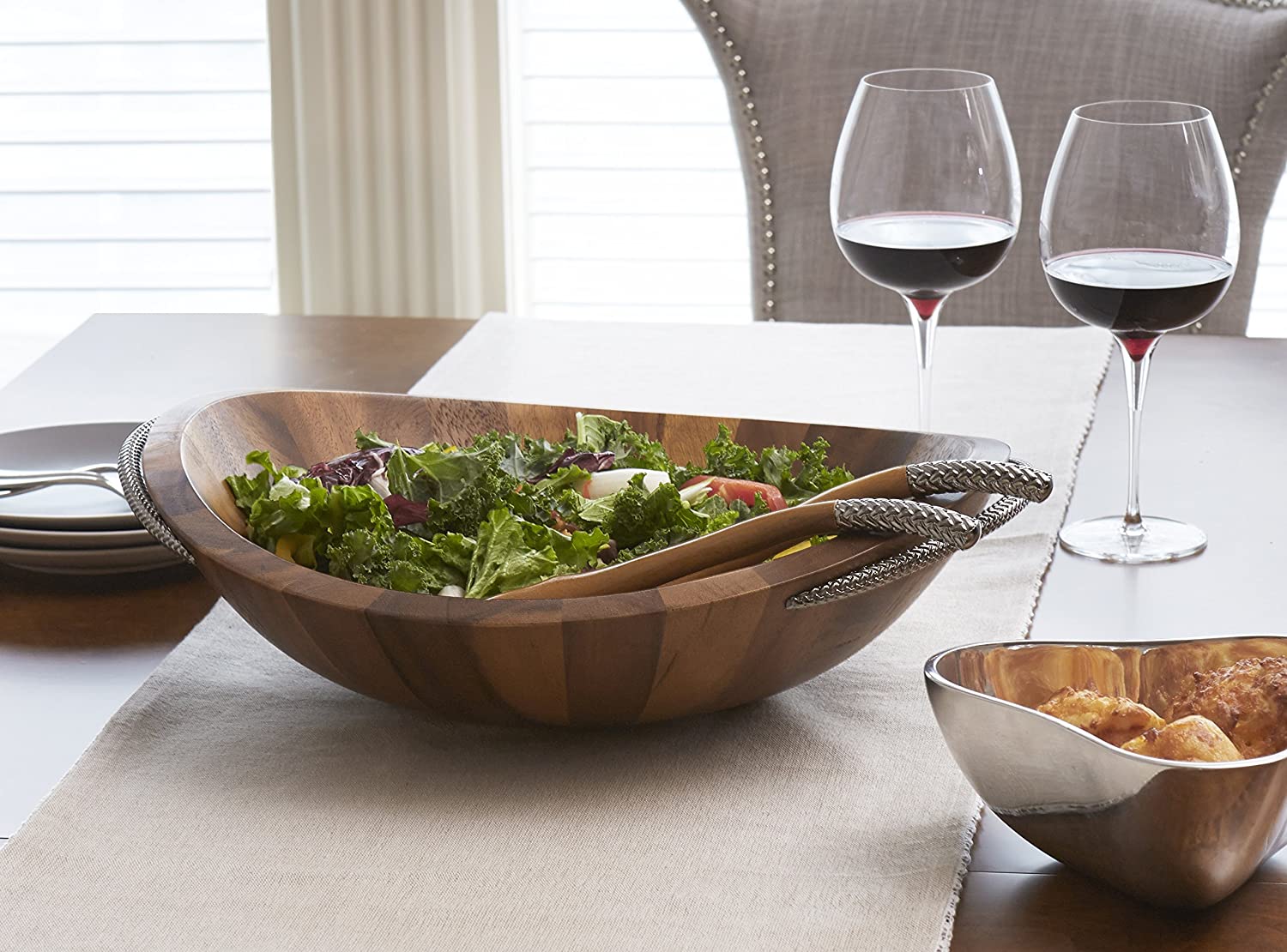 salad bowl on table with two wine glasses