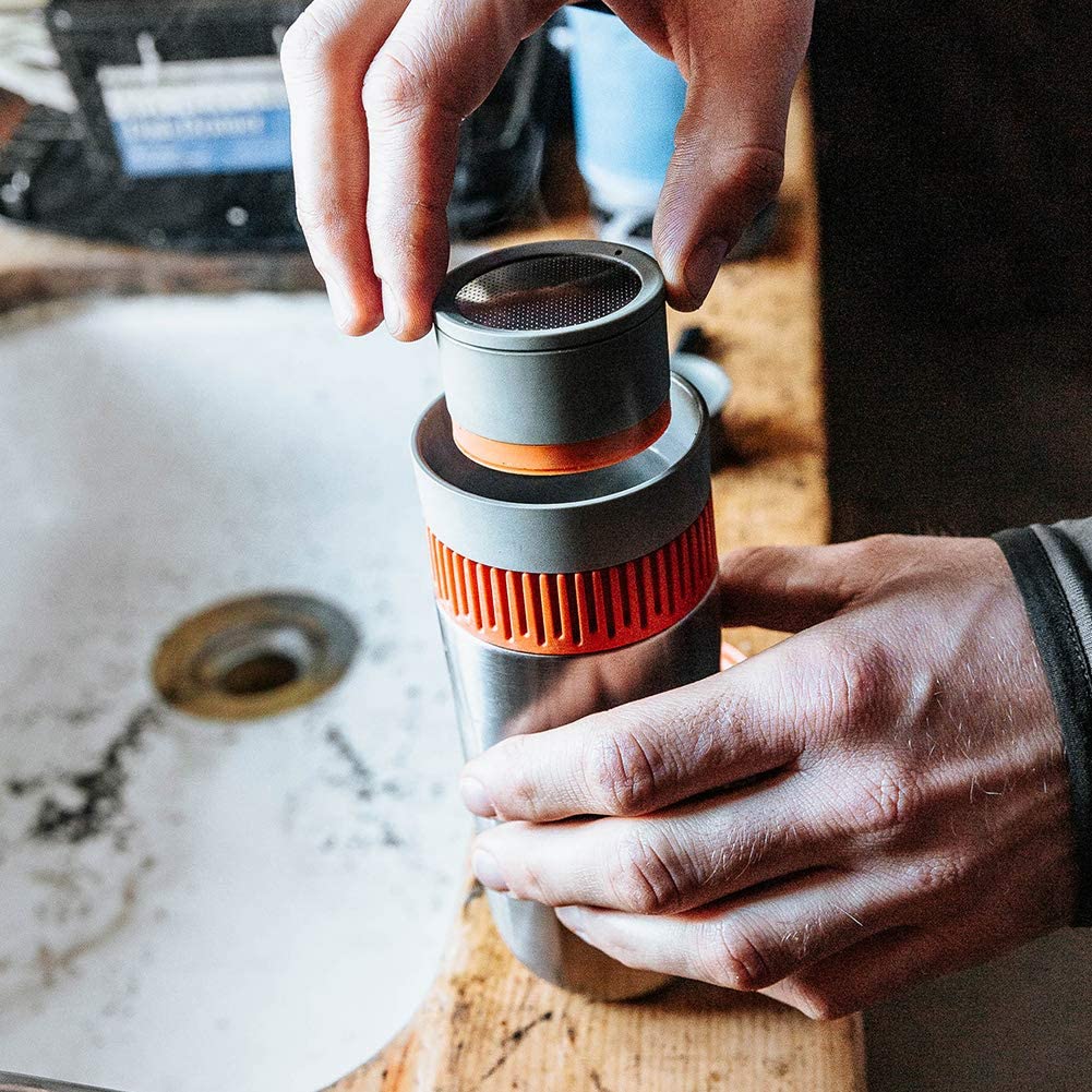 persons hand putting together pieces of pourover coffee travel mug