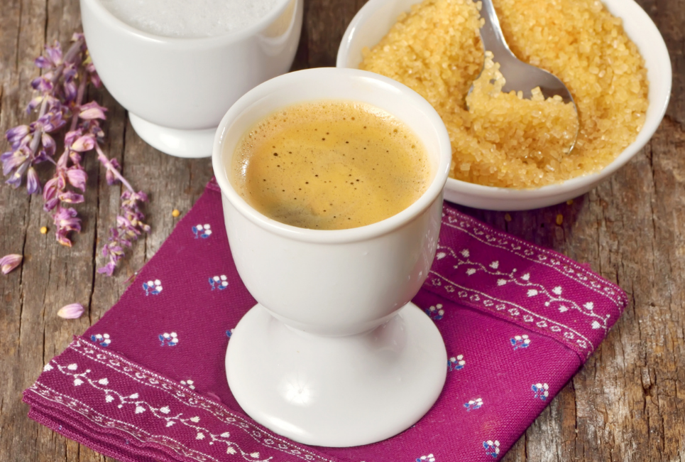 espresso cup on pedestal with bowl of raw sugar