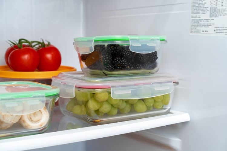 food storage containers in fridge filled with produce